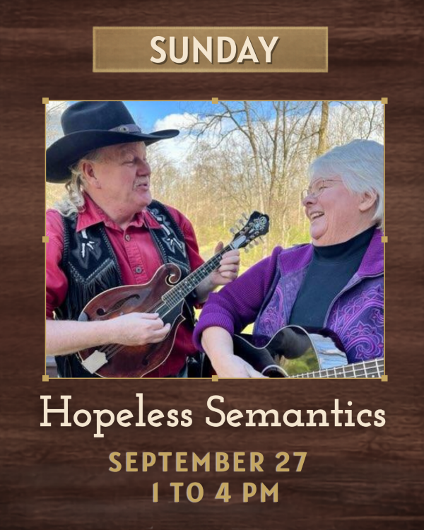 A man in a cowboy hat looking at a woman they are both holding guitars
